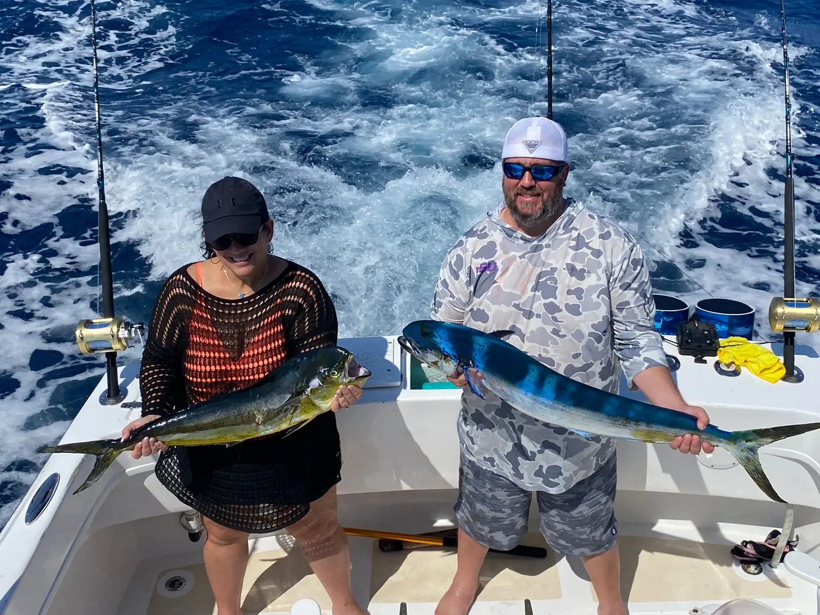 Guest holding a roosterfish aboard a Cabo fishing charter